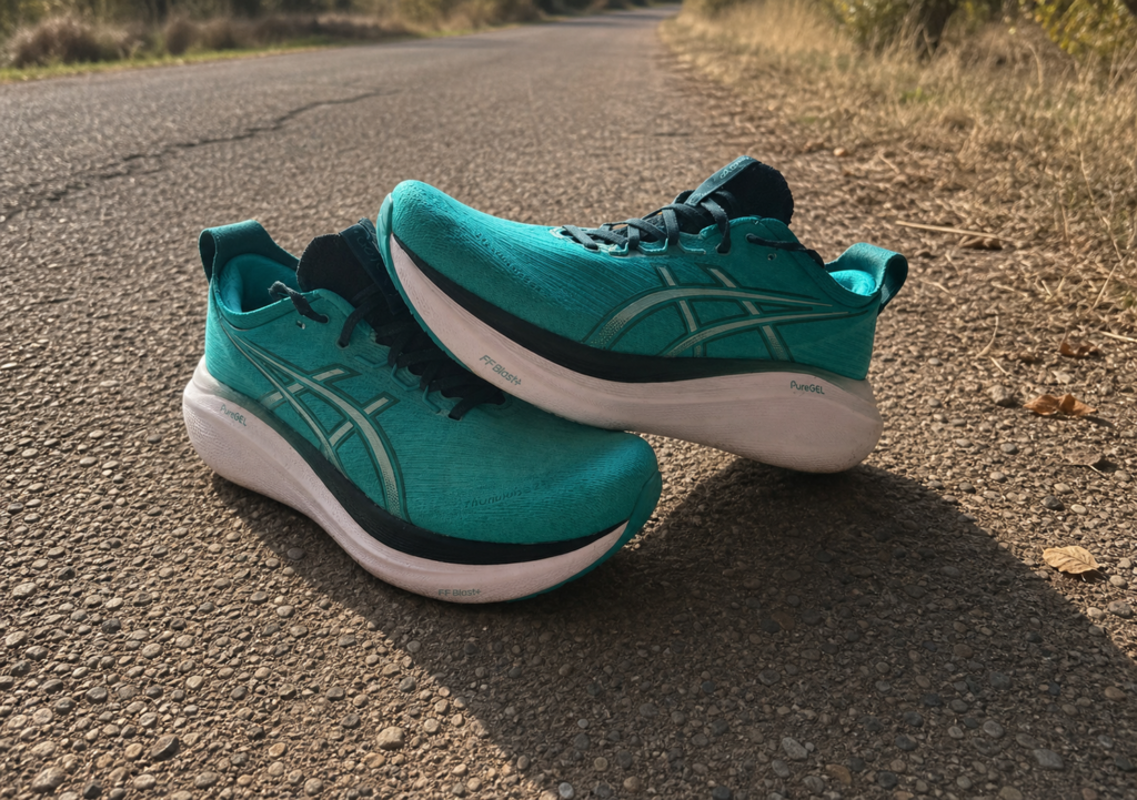 ASICS Gel-Nimbus 27 Wave Teal posées sur une route