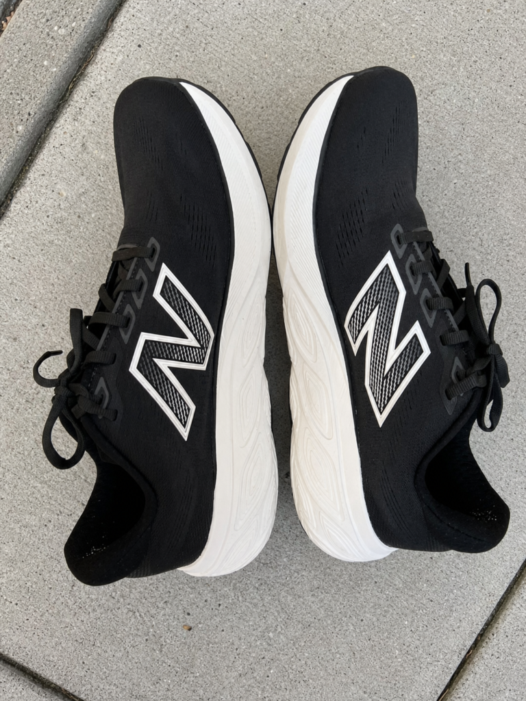 Profil et tige de la New Balance 880v15 noire et blanche sur trottoir