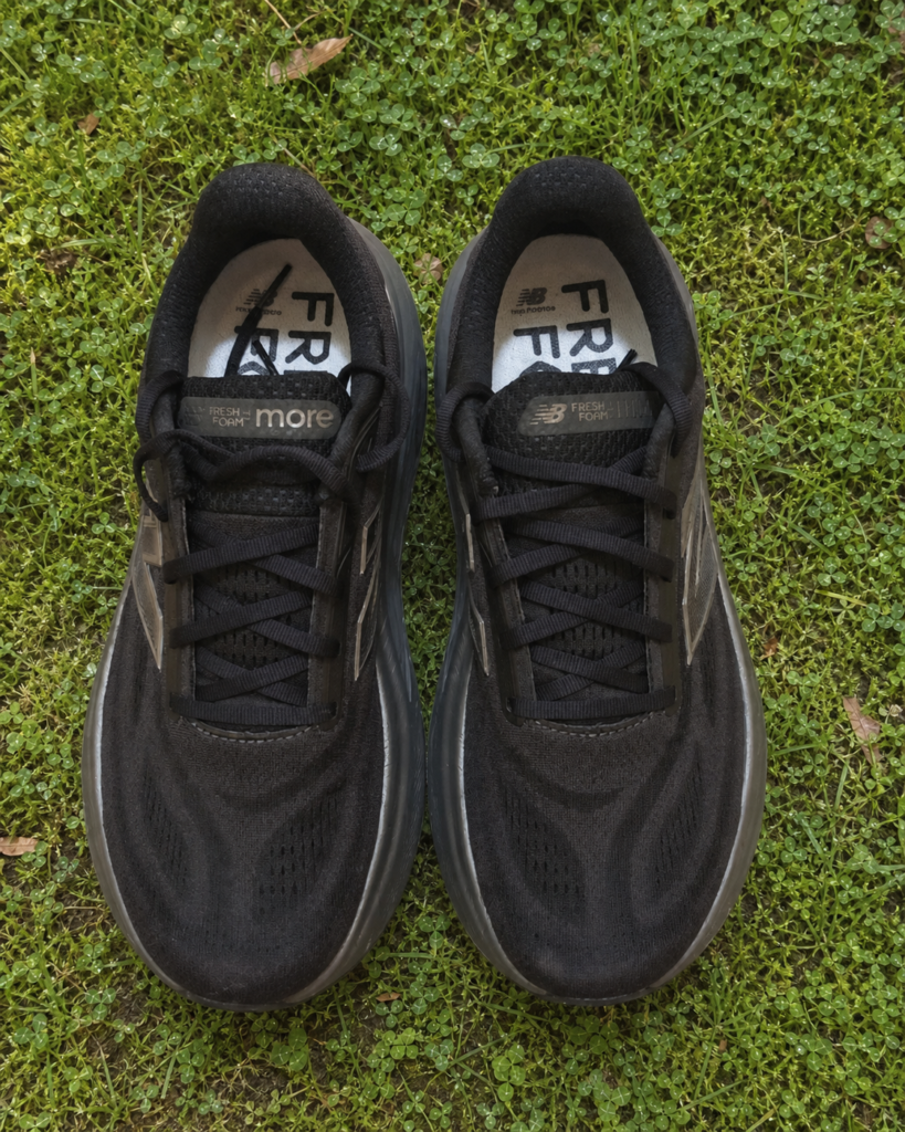 Vue du dessus et laçage des New Balance Fresh Foam X More v6 noires sur une pelouse humide
