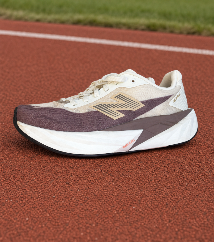 New Balance FuelCell Rebel v5 homme crème et mauve sur piste d'athlétisme