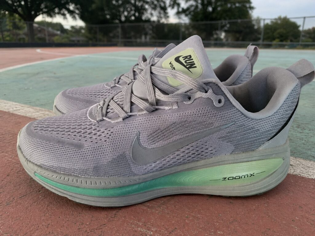 Nike Vomero 18 homme gris lilas et vert menthe sur un terrain sportif extérieur