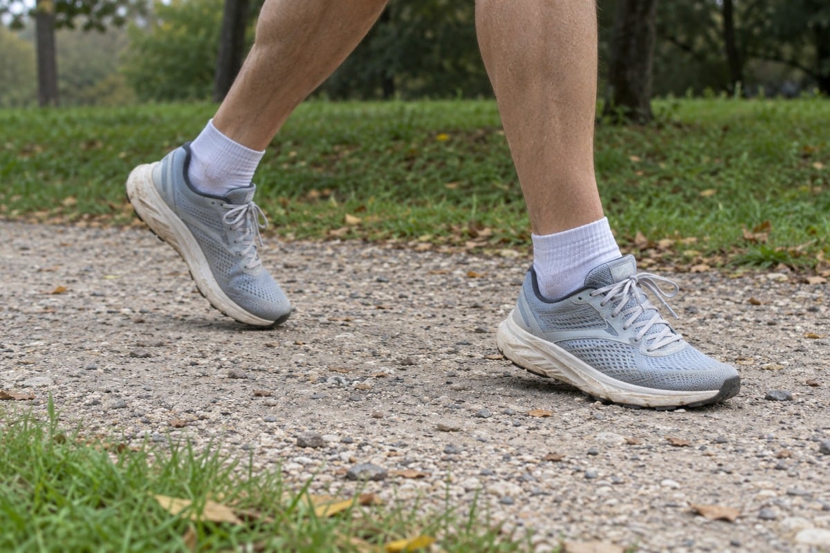 Coureur léger vu uniquement au niveau des jambes avec chaussures de running sur un chemin de parc